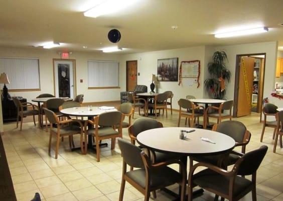 Dining area with tables and chairs in a senior living facility