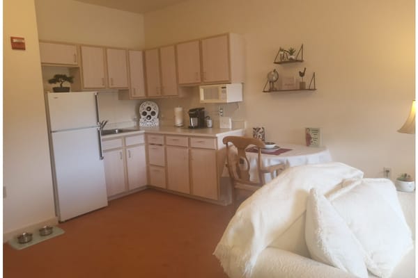 Cozy kitchenette in a Stafford Suites room with dining table and appliances.