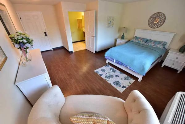 Bright and inviting bedroom with a bed, side tables, and a cozy seating area.