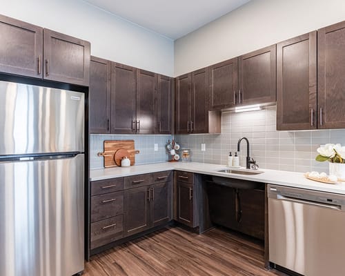 Stylish kitchen with dark cabinetry and stainless steel appliances