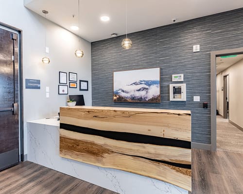 Modern reception area with wooden desk and mountain artwork