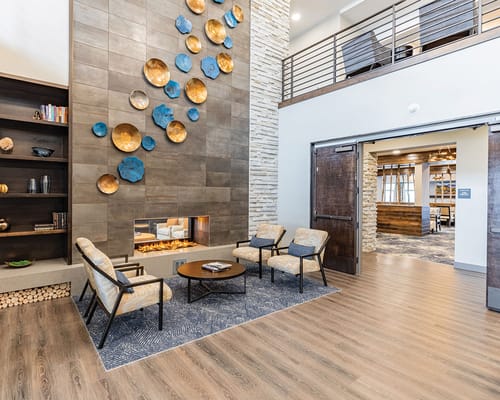 Inviting lobby with seating, fireplace, and art at Terra Bluffs.