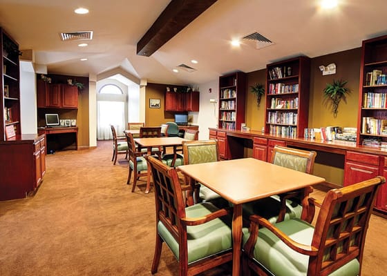Library area with bookshelves and tables in The Heritage at College View.