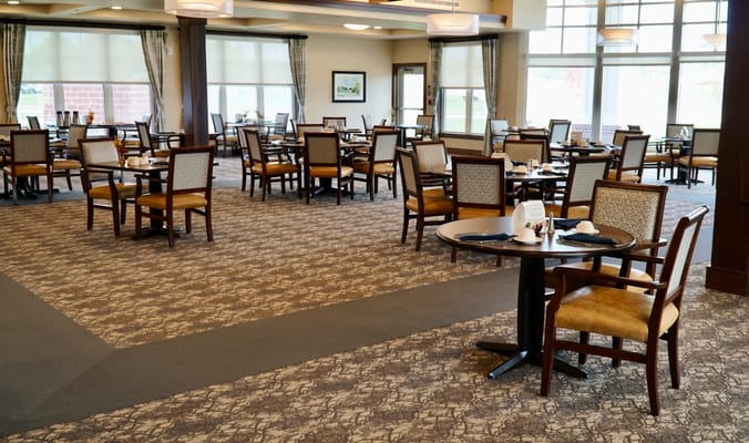Spacious dining room with tables and chairs set for meals.