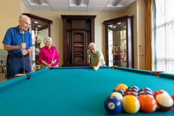 Seniors playing pool at a senior living facility