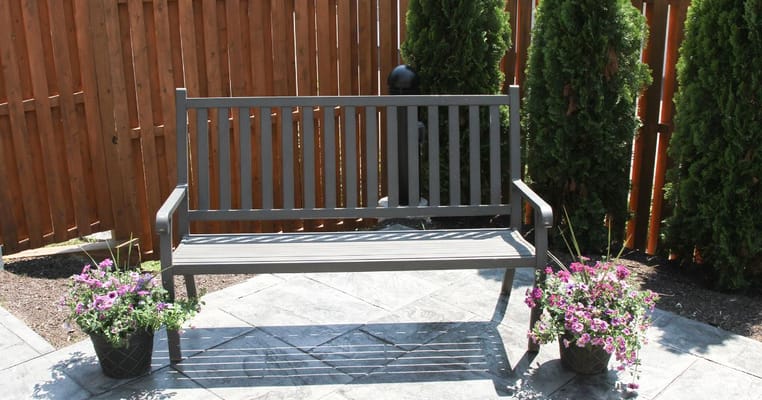 Outdoor bench surrounded by flowers in a landscaped area