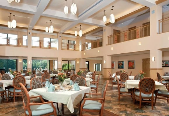 Bright and spacious dining room with tables and chairs set for meals