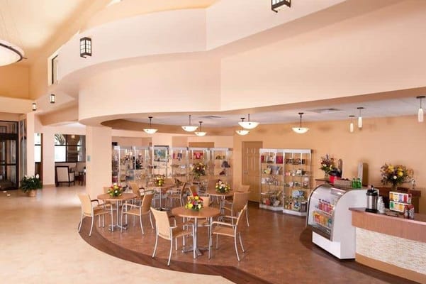 Bright and inviting common area with tables and shelves.