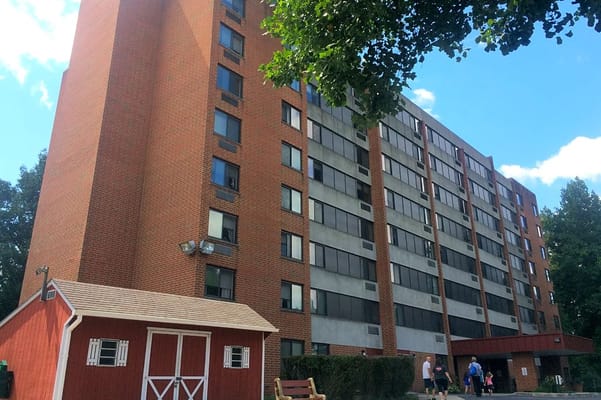 Tall brick building of Tower At Falling Spring with nearby red shed.