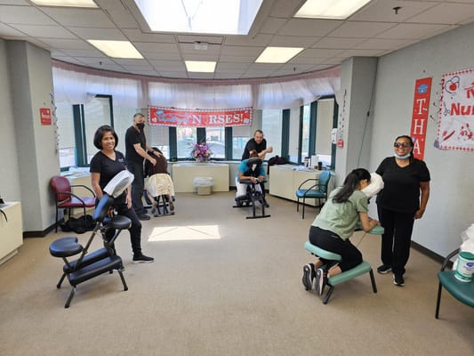 Residents enjoying a chair massage in a wellness activity.
