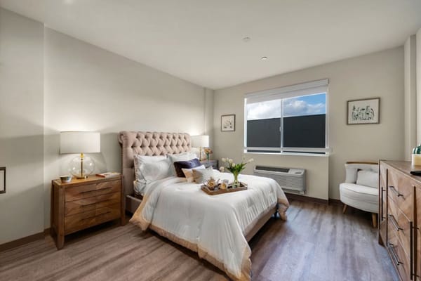 Bright and inviting bedroom with a bed, nightstand, and window.