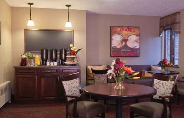 Coffee station with beverages and seating area in senior living facility