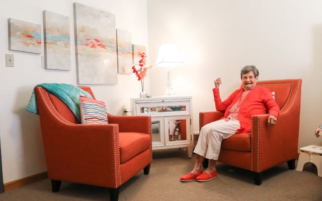 Senior resident sitting in a cozy room with bright decor