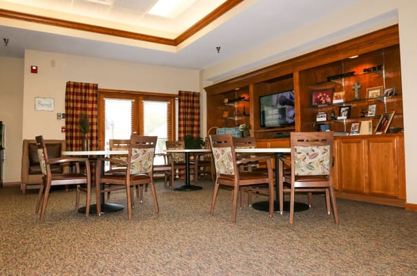 Cozy common area with tables and chairs surrounded by natural light