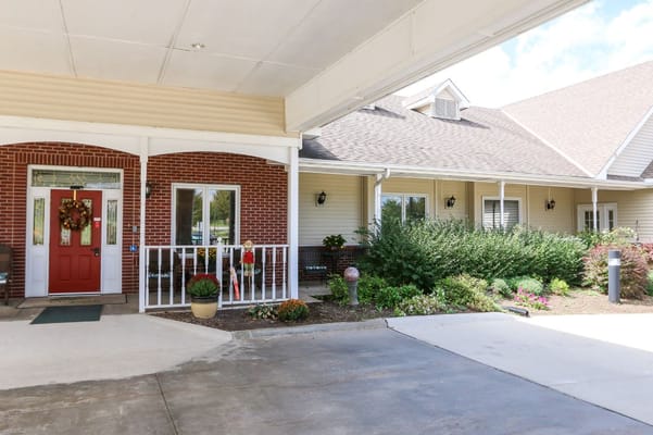 Front entrance of Vintage Park at Baldwin City with flowers and a wreath