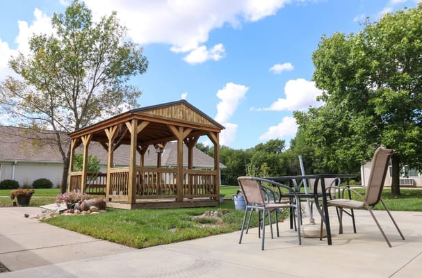 Wooden gazebo with outdoor seating area and landscaping