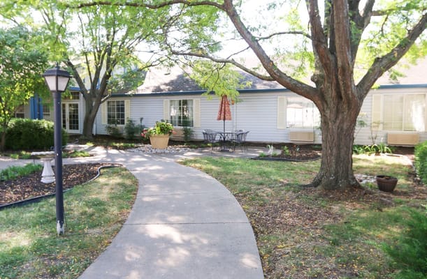 A winding path through a landscaped garden with seating area.