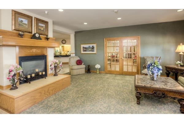Inviting living room with a fireplace and decorative flowers.