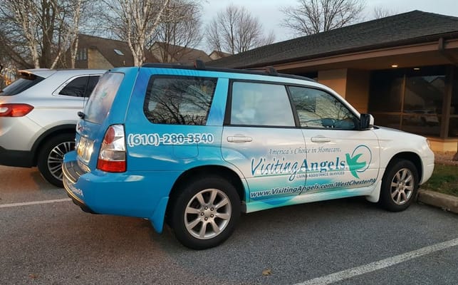 Blue Visiting Angels vehicle parked outside the facility