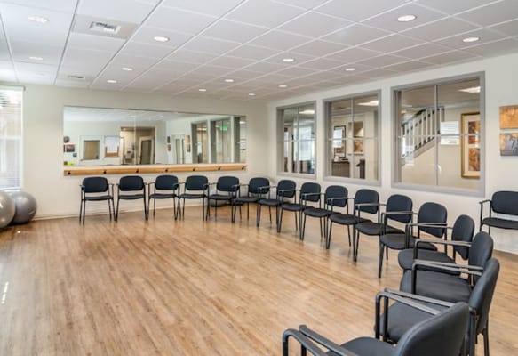 A bright activity room with chairs arranged in a circle