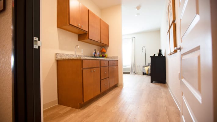 Interior view of a resident room with cabinets and wood flooring