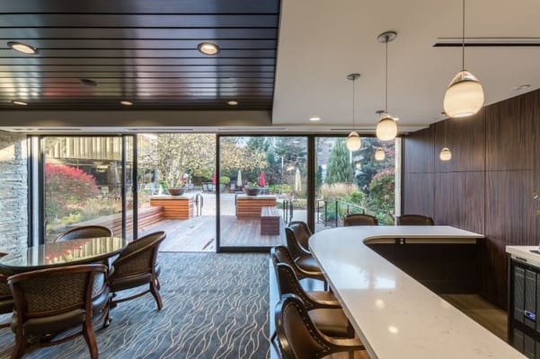 View of a lounge area with dark wood decor and a garden outside