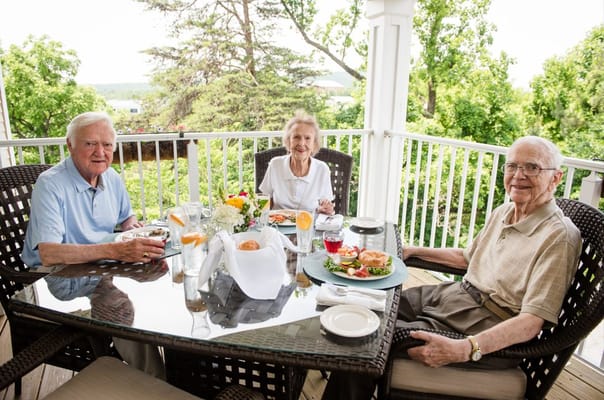 Three residents enjoying a meal on a patio
