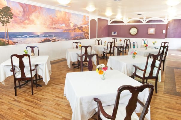 Bright dining room with tables set for residents