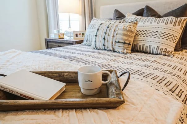 Cozy bedroom setup with a coffee cup on a tray