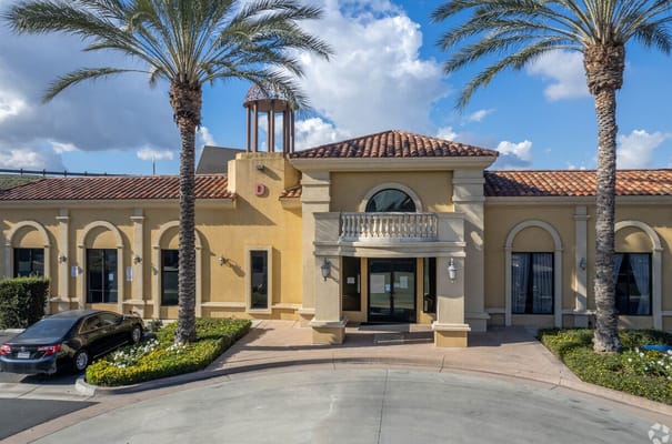 Front entrance of Ivy Garden Senior Condos with palm trees.