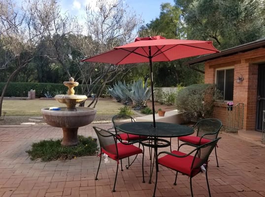 Outdoor patio area with chairs and a fountain
