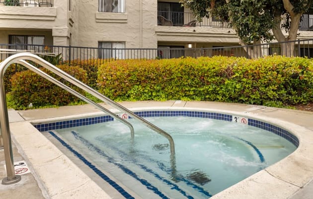 Hot tub with handrails surrounded by greenery at Laguna Estates