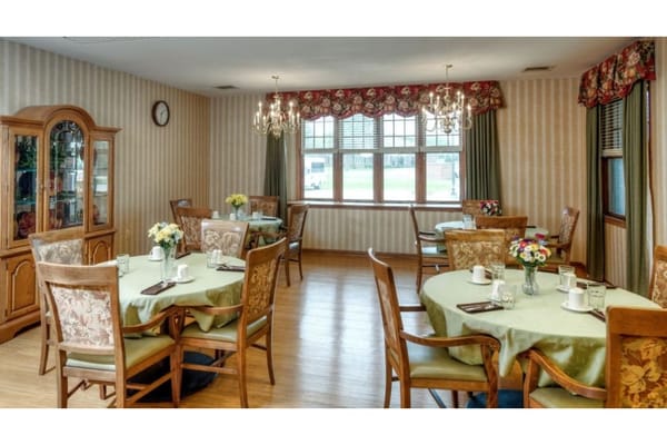 Cozy dining room with tables set for residents