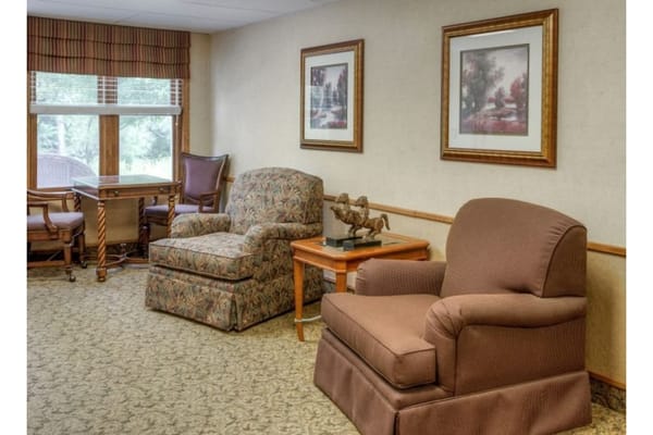 Comfortable seating area with two chairs and a table near a window.