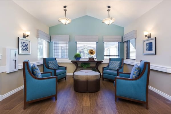 Interior common area with blue chairs and natural light