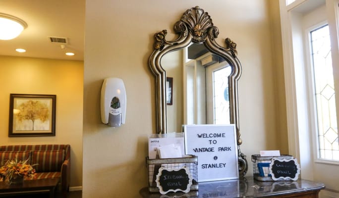 A welcoming setup with a decorative mirror and sign at Vintage Park at Stanley.