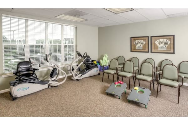 Exercise equipment and chairs in a bright room