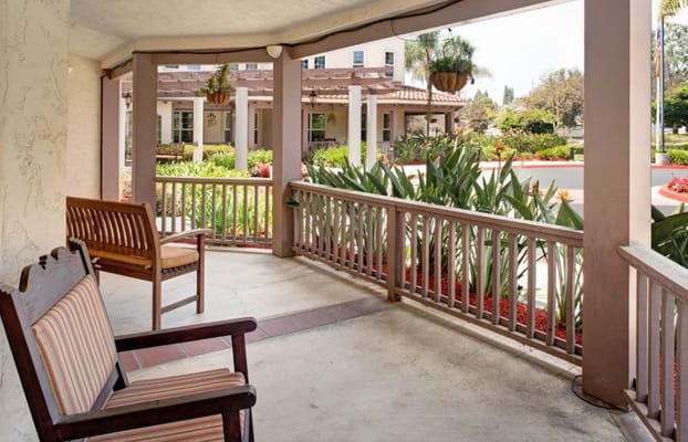 Seating area on the porch overlooking lush greenery.