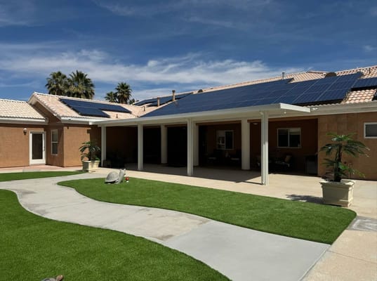 Backyard view featuring solar panels and landscaped garden