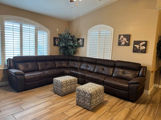 Lounge area with brown sectional sofa and textured ottomans