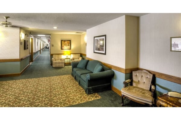 Comfortable seating in a common area with a hallway in the background.