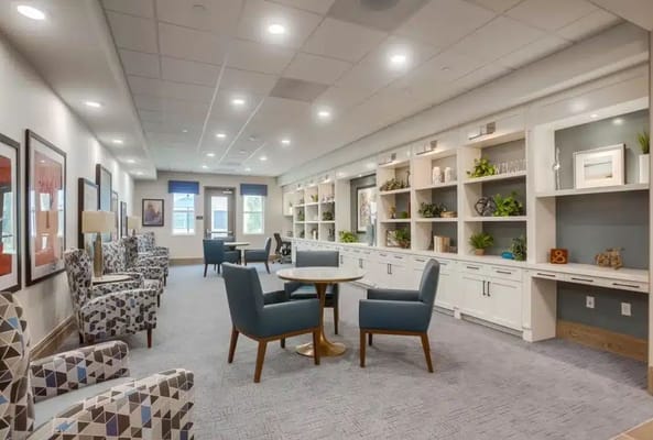 Bright and inviting common area with seating and shelving.