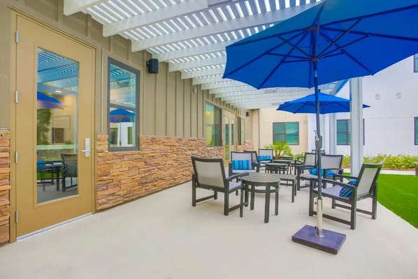 Cozy outdoor seating area with blue umbrellas and stone accents