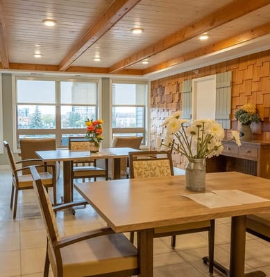 Interior view of a bright common area with tables and chairs