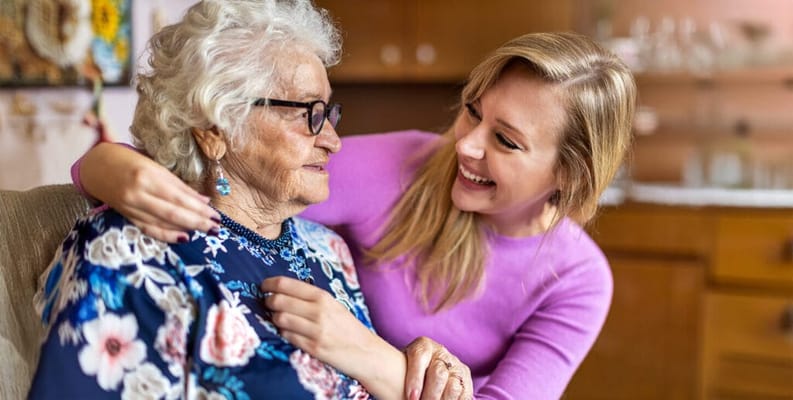 A resident and staff member sharing a joyful moment