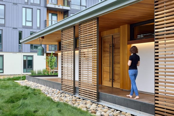 A woman entering a modern assisted living facility
