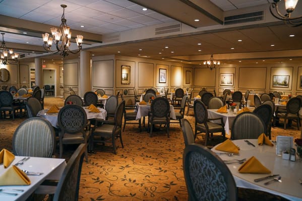 Dining room with neatly arranged tables and yellow napkins