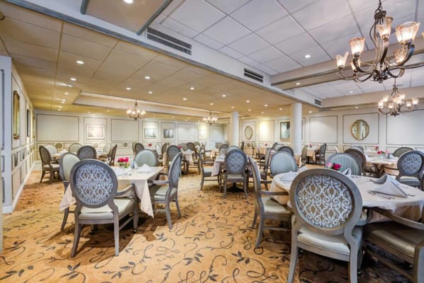 Elegant dining room setup with round tables and chandeliers