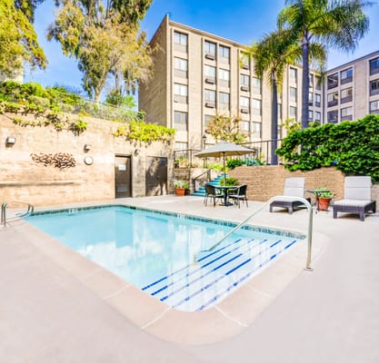 Outdoor swimming pool area with lounge chairs and umbrellas