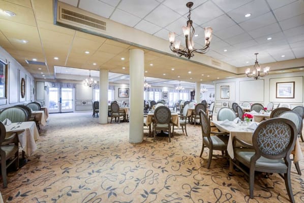 Elegant dining room with tables set for residents